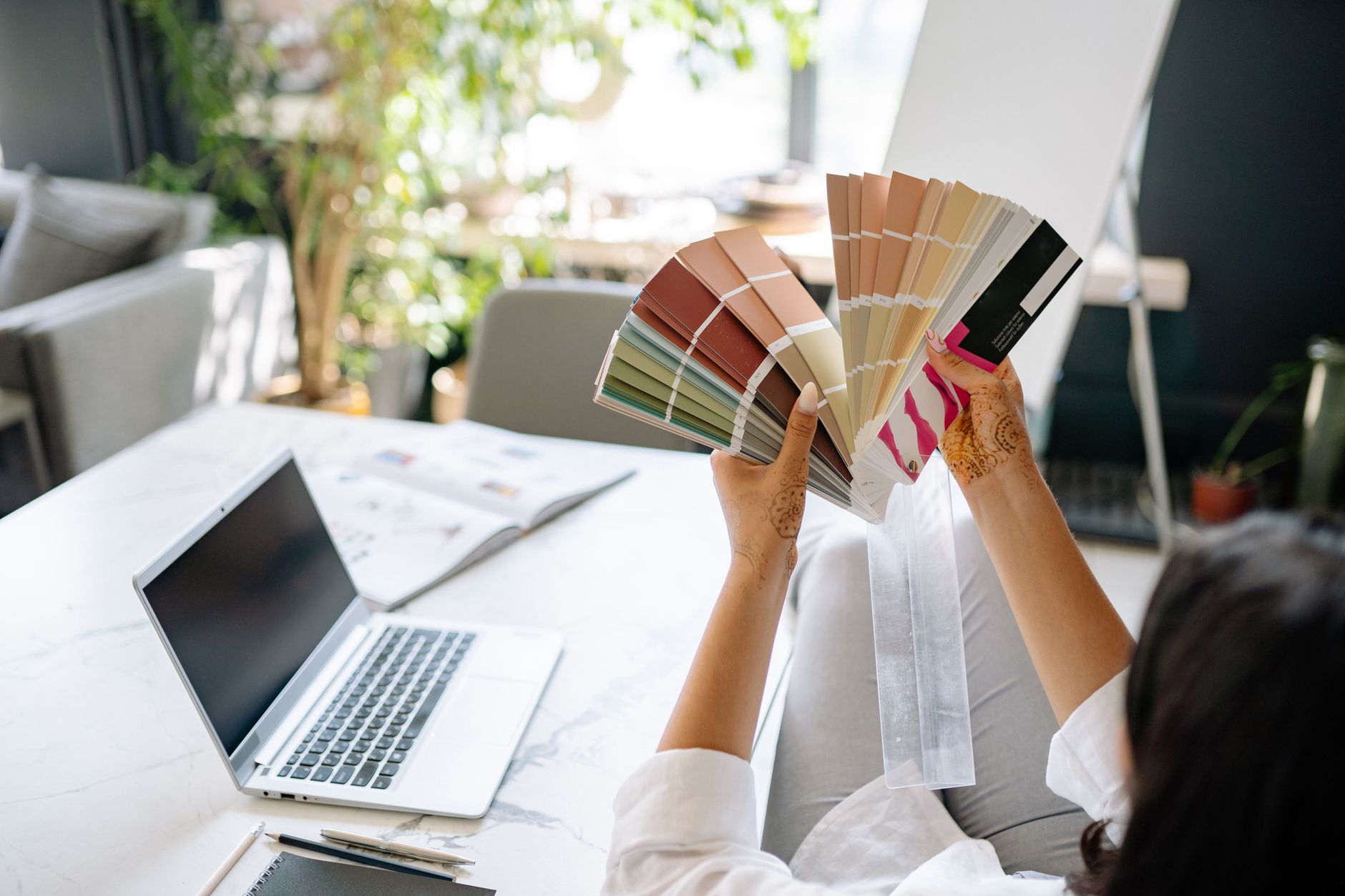 Close-up of hands arranging fruit-inspired brand palette colour swatches on a studio desk